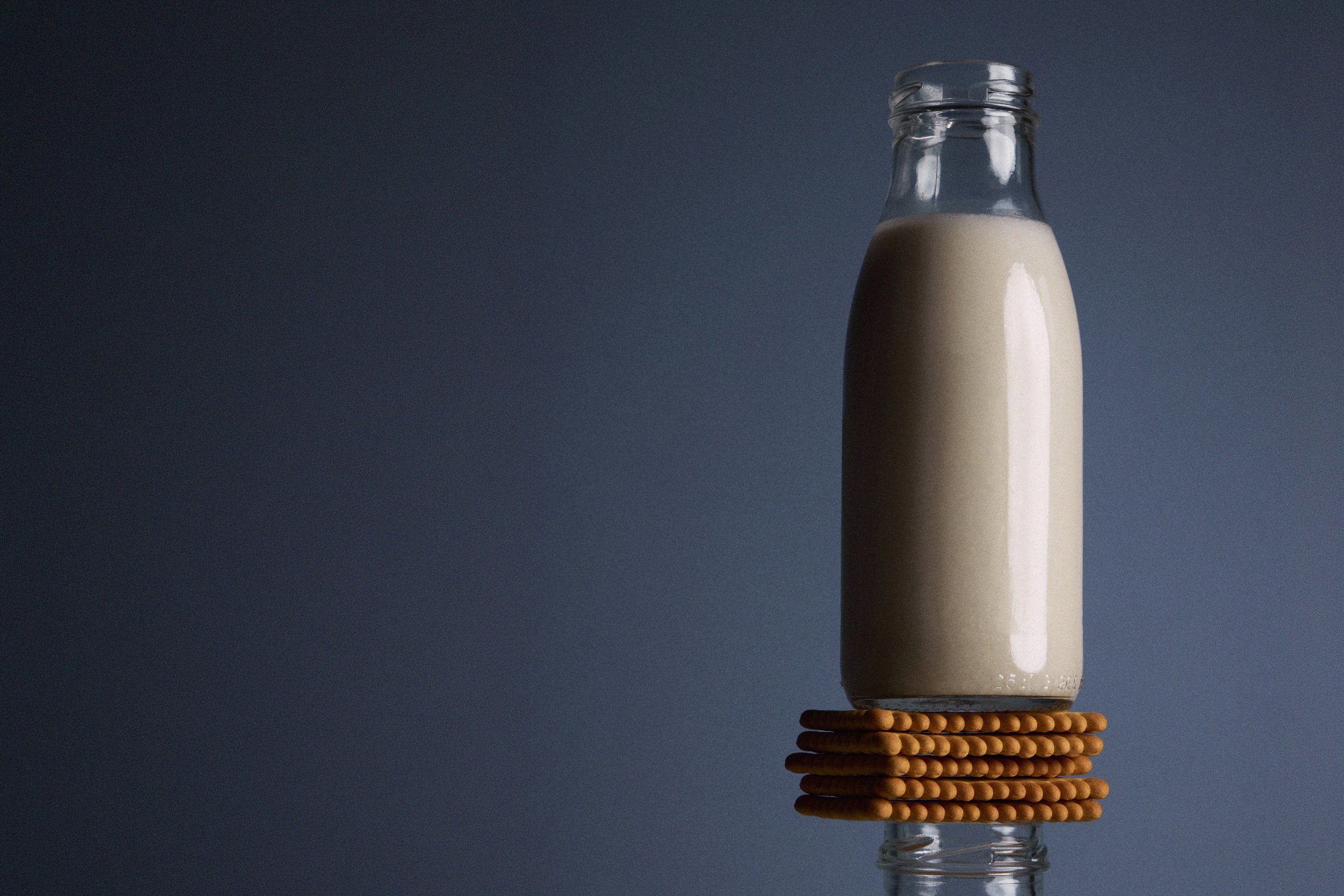 A milk bottle balanced above a stack of biscuits